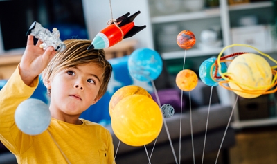 Child playing with space-related items